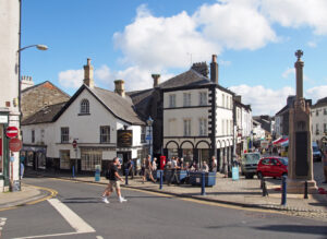 England -the town centre in Ulverston Cumbria with people walking past shops and the weekly market