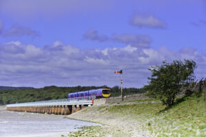 A modern train crossing the Arnside viaduct over the estuary of the River Kent. England