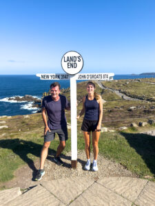 Land's End! 2 walkers pose on the South West Coast Path